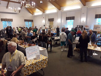 Picture of large room with Fungust Fest exhibits and attendees